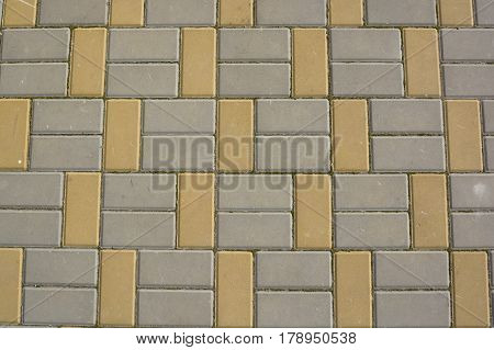 Texture of road surface with grey and yellow pave stones