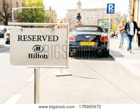 BUCHAREST ROMANIA - APR 1 2016: Resrved parking sign in front of the Hilton five star luxury hotel with silhouette of Bentley luxury convertible care parked