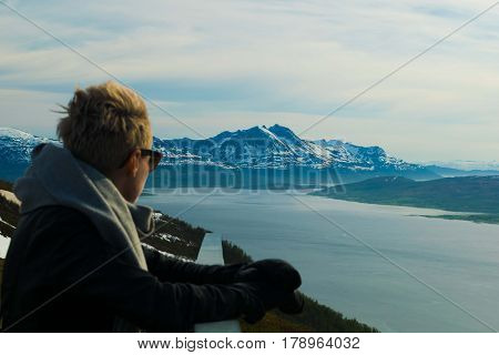 A beautiful girl looking at mountains inside artic circle