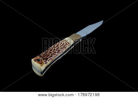 Back Of A Vintage Pocketknife With Horn Handle And Brass Guard - Black Background