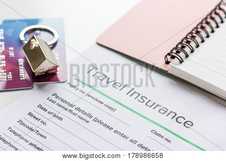 Traveling concept with insurance application form, notebook and credit cards on white table background