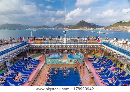 ST MAARTEN CARIBBEAN - SEPTEMBER 22 2013: People rest on the deck of a cruise liner near the St.Maarten island