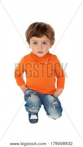 Playful baby on knees with orange jersey isolated on a white background