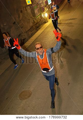 STOCKHOLM SWEDEN - MAR 25 2017: Happy man in reflex vest running in a dark tunnel in the Stockholm Tunnel Run Citybanan 2017. March 25 2017 in Stockholm Sweden