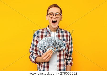 Screaming Man In A Plaid Shirt Holds Money In His Hands And Looks Into The Camera On A Yellow Backgr