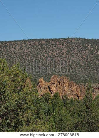 A Rugged Rock Formation In The Trees With A Hill As A Background At Prineville Reservoir In Central 