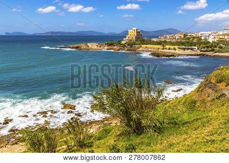 Mediterranean Seacoast In Alghero City, Sardinia, Italy. Spring Flowers And Trees On Foreground, Col