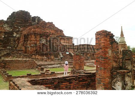 Female Tourist Looking At The Awesome Remains In Wat Mahathat Temple Within Ayutthaya Historical Par