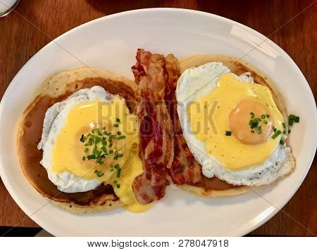 Salted Pancakes With Hollandaise Suace, Eggs And Crispy Bacon For Breakfast. Salty Fast Food.