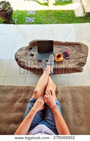 Man With Coffee / Tea And Laptop On A Home Porch.