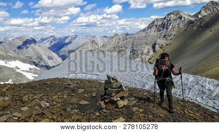 A Female Hiker Backcountry Hiking Through The Remote, Secluded, And Beautiful Rocky Mountains In Kan