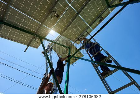 Mounters Team Installing Solar Batteries On Houses Roof. Innovative High-tech Exterior Solution. Env