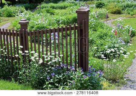 Brown Wood Fencing That Marks Off Pretty Landscaped Garden With Gorgeous Array Of Seasonal Summertim