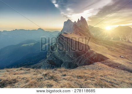 Epic Misty Morning Landscape Of Dolomites Alps. Majestic Seceda Peak During Sunrise, In Fog. Locatio
