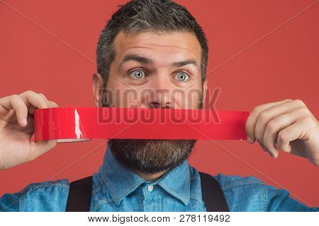 Bearded Man With Wrapping Adhesive Tape Around Mouth. Businessman Silenced With Duct Tape Over His M