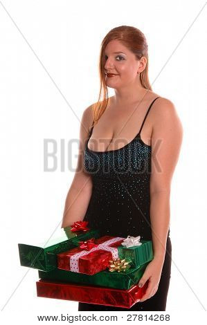 Kvinna på en julfest som bär en armload jul presenterar.