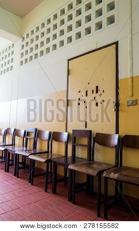 Unused Student Chair In Front Of The Broken Door Of An Old Classroom