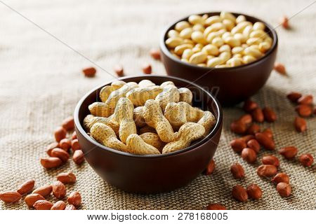 Peanuts In The Shell And Peeled Closeup In A Cup. Background With Peanuts. Roasted Peanuts In The Sh