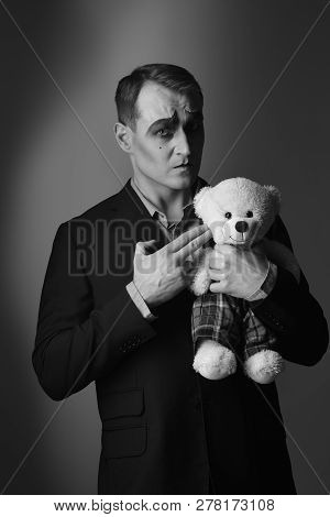 Imitating A Criminal Act. Theatre Actor With Hand Gesture Killing Teddy Toy. Stage Actor Shooter Wit