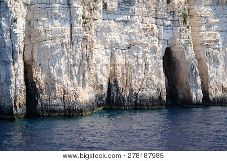 Blue Caves On The Shore Of Paxos Island Seen From The Sea