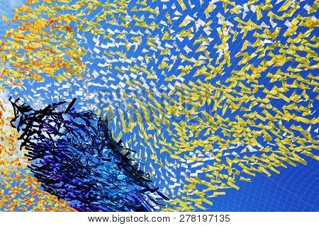 Abstract Colorful Background Made From Lot Of Diversity Cloth Against Blue Sky