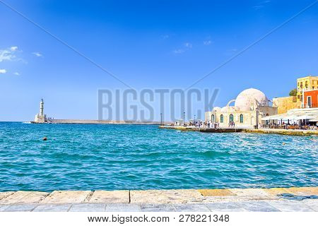Travel Ideas. Chania Old Port And Venetian Harbor With Ancient Lighthouse On Background.horizontal I