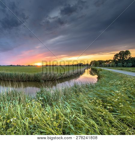 Wide Angle View Of Landscape Over River Bend At Sunset In Flat Agricultural Landscape In Groningen P