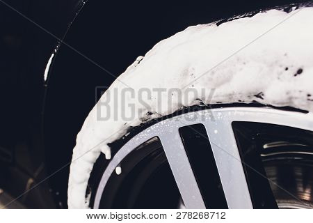 Car Care Or Car Detailing Process. Using Black Sponge To Washing The Tire. Blacker Rubber.