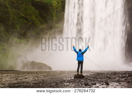 Single Man Standing Near Scogafoss Waterfall In Iceland And Spread His Hands. Travel Summer Nordic C