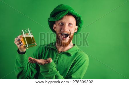Patricks Day Party. Portrait Of Excited Man Holding Glass Of Beer On St Patricks Day Isolated On Gre