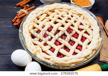 Raw Cherry Pie In A Glass Round Form And Ingredients For Making Cake  - Flour, Egg, Cherry, Brown Su