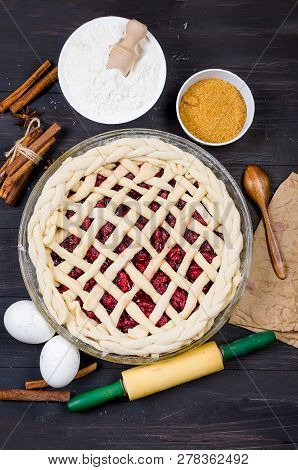 Raw Cherry Pie In A Glass Round Form And Ingredients For Making Cake  - Flour, Egg, Cherry, Brown Su