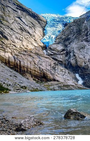 Norway, Olden Landmark Nature Gem, Lake And Briksdal Or Briksdalsbreen Glacier With Melting Blue Ice
