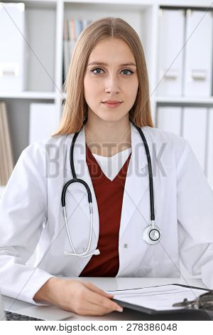 Close-up Of A Unknown Female Doctors Hands. Physician At Working Place Ready To Consult And Halp Pat