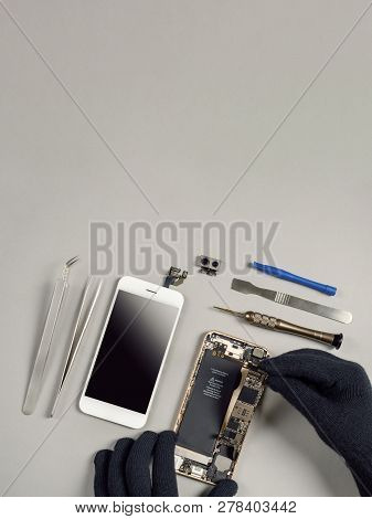 Technician Or Engineer Disassembling Components Broken Smartphone And Take Off Logic Board For Repai