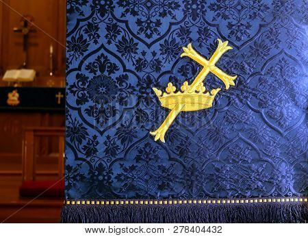 Close-up Of A Gold Cross Through A Crown On A Traditional Indigo Church Advent Lecturn Parament With