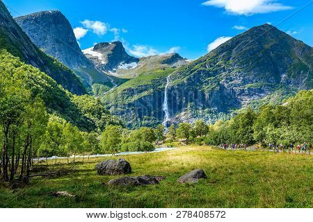 Pathway To Briksdal Or Briksdalsbreen Glacier In Olden, Norway With Green Mountains, Snow And Waterf