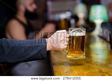 Beer Mug On Bar Counter Defocused Background. Glass With Fresh Lager Draft Beer With Foam. Male Hand