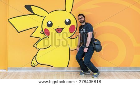 Tokyo, Japan - August 2018: Happy Tourist With A Pokemon Pikachu Figure At Pokemon Center Store In S