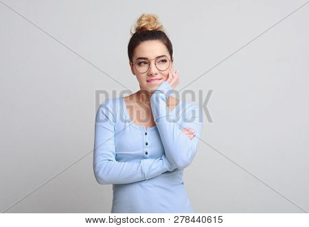Young Tricky Woman Having Something In Mind With Facial Expressions, Over Gray Background