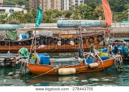 Hong Kong, China  - May 12, 2010: Closeup Of Orange Garden Sloop Of Houseboat Docked In Harbor. Gree