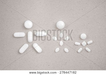 People Made From Pills On The сardboard Background. Concept