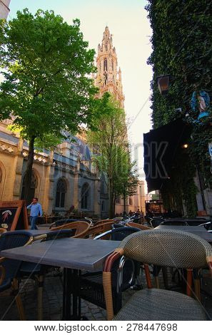 Antwerp, Belgium - May 02, 2018: Cozy Cafe In A Quiet Street With Picturesque View To The Tower Of T