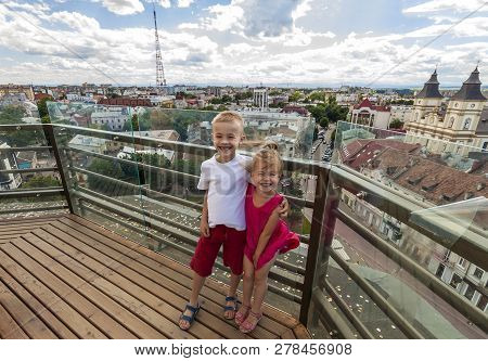 Two Smiling Happy Little Children Boy And Girl Standing On Top Of View Deck Of High Building With Ci