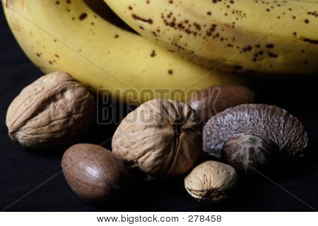 Blandede nødder ved siden af bananer