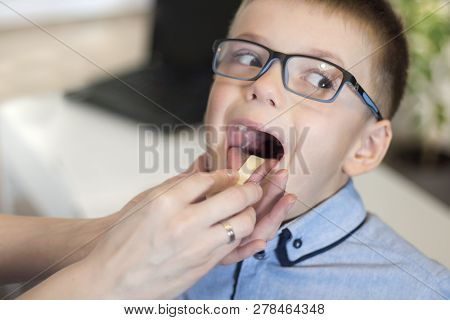 A Boy With Open-mouth During A Medical Examination. The Doctor Checks The Throat And Tonsils Of The 
