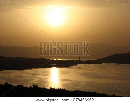 Splendid view of the golden sunrise at the Adriatic coast with the sun reflected in the sea.
