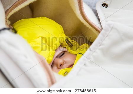 Infant Sleep In Baby Stroller In Winter Forest.  Warmly Dressed. Yellow Jumpsuit.
