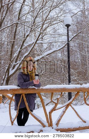 Girl In A Sweater Holding A Thermomug With Some Drink In A Winter Park