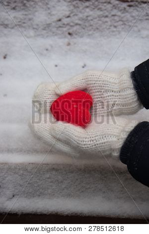 Hands In White Mitterns With Red Heart On The Snow Background